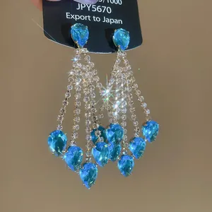 Detailed view of glamorous blue teardrop tassel earrings with sparkling rhinestones