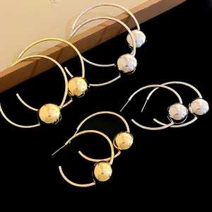 Elegant gold and silver hoop earrings with metallic spheres in minimalist style
