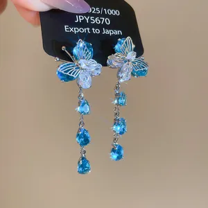 Detailed macro view of sparkling blue butterfly tassel earrings with teardrop crystals