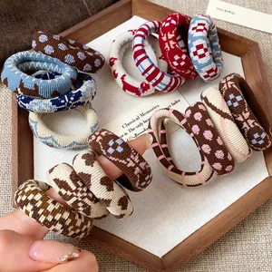 Variety of printed fabric elastic hair ties with vintage patterns like houndstooth
