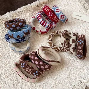 Close-up of assorted fabric elastic hair ties with diverse patterns on a textured background.