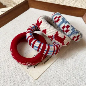 Close-up of four fabric printed elastic hair ties featuring diverse geometric and striped patterns