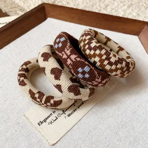 Detailed view of four fabric hair ties featuring houndstooth and heart patterns.