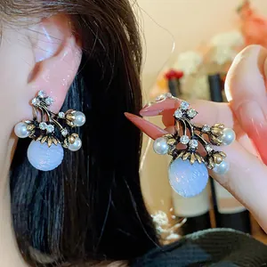 Vue détaillée de boucles d'oreilles françaises vintage avec perles et pierres bleues