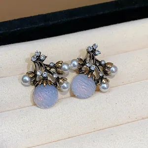 Détail de boucles d'oreilles vintage françaises avec perles, strass et perles bleues