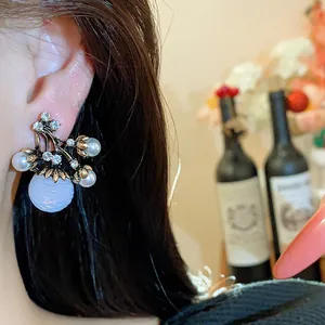 Détail d'une boucle d'oreille vintage de style français avec perles et strass sur l'oreille