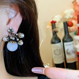 Vue détaillée d'une boucle d'oreille vintage française avec perles et strass sur l'oreille