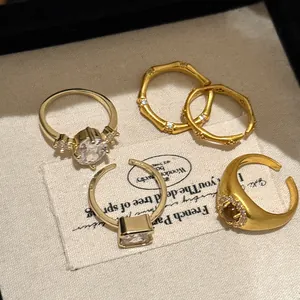 Close-up of vintage gold bamboo and zircon open rings with various gemstone cuts
