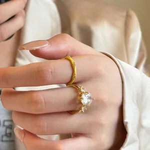 Close-up of vintage gold-toned bamboo ring and zircon solitaire ring set for women