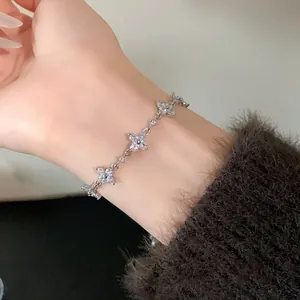 Detailed close-up showing shiny zircon flower charms on an adjustable silver bracelet for women.