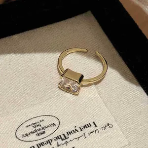 Detailed view of a gold bamboo-knot ring featuring a radiant square-cut zircon.