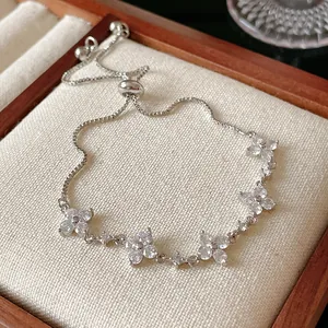 Detailed view of an adjustable silver bracelet featuring sparkling zircon flower charms