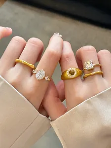 Close-up detail of several New Chinese style brushed gold rings set with zircon stones