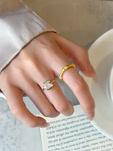Detail view of vintage brushed gold bamboo ring and elegant square zircon open ring set