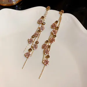 Close-up detail of elegant pink rose flower long tassel earrings with rhinestones