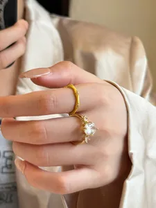Exquisite detail of gold-plated brushed bamboo ring and large zircon ring worn on a hand