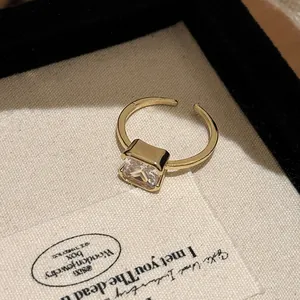 Detailed macro shot of an elegant gold-tone open ring with a square-cut clear zircon