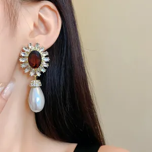 Boucles d'oreilles fleur vintage en cristal avec grande perle goutte blanche sur modèle