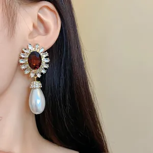 Détail de la boucle d'oreille fleurie en cristal vintage avec perle en forme de goutte
