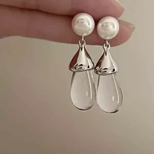 Vista detallada de elegantes pendientes de gota de resina con perlas y capuchas plateadas (89 Chars)