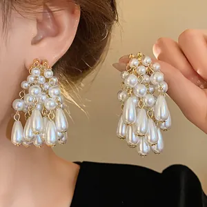 Close-up detail of luxury pearl tassel earrings with teardrop beads and gold accents.