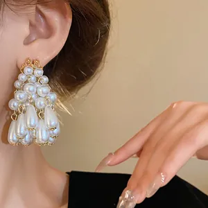Detail shot of elegant pearl tassel earrings with silver needle and teardrop pearls
