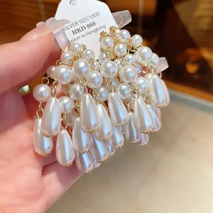 Close-up of elegant silver needle teardrop pearl tassel earrings with a luxury finish