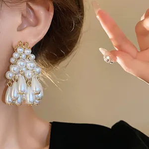 Detailed view of elegant French style white waterdrop pearl tassel earrings on model ear
