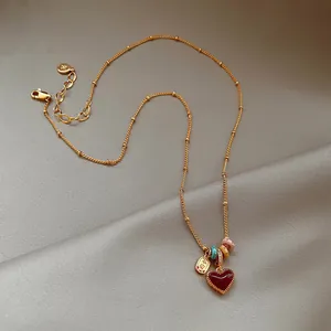 Élégant collier ras du cou doré avec pendentif cœur rouge et perles