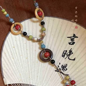 Collana lunga intrecciata bohémien con perline di ceramica colorate e anelli di legno