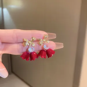 Élégantes boucles d'oreilles tulipe en velours rouge avec nœud doré et cristal