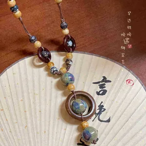 Dettaglio di perle in ceramica etnica e anelli di legno su una collana in corda