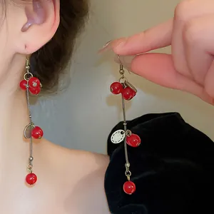 Gros plan détaillé de longues boucles d'oreilles pendantes rouges vintage portées par le mannequin