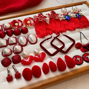 Vue détaillée d'une élégante collection de bijoux rouges et perles sur un plateau en velours