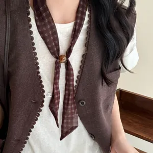 Detailed view of a retro brown plaid scarf necklace featuring an elegant amber bead buckle