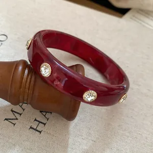 Vintage red resin bangle with gold-rimmed crystal embellishments for women's retro style