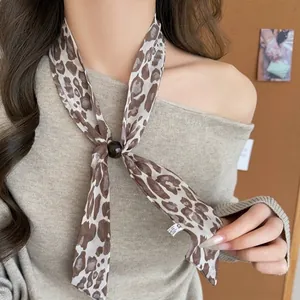 Close-up of retro leopard print silk scarf necklace on a woman wearing beige sweater.