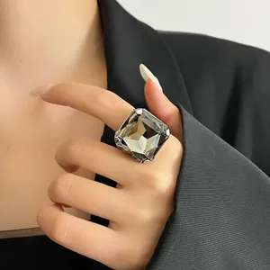 Primo piano di un anello di cristallo quadrato oversize su un dito