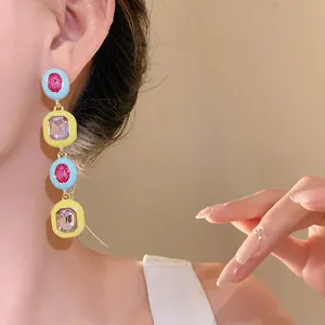 Nahaufnahme von bunten Emaille-Ohrhängern im Dopamin-Stil mit funkelnden Kristallen