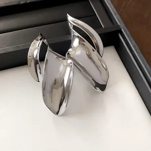 Gedetailleerde weergave van metalen bladoorbellen met glanzende zilveren finish