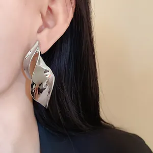Detailweergave van zilverkleurige onregelmatige bladvormige metalen oorsteker op een model