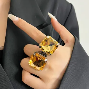 Primo piano di anelli aperti in cristallo ambra quadrati per uno stile moda.