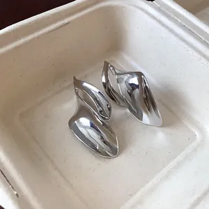 Macro-detailweergave van onregelmatige metalen bladoorbellen met gepolijste zilveren spiegelglans