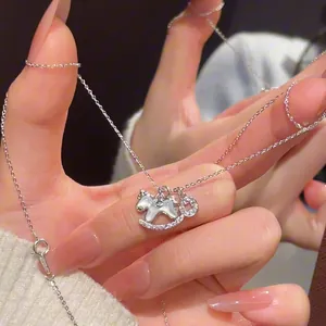 Gros plan détaillé du collier cheval argenté avec accents en zircon et breloque pièce.