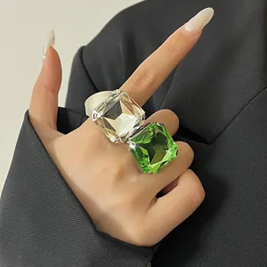 Vista dettagliata di un anello aperto con cristalli quadrati oversize in verde e bianco