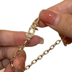 Minimalist gold horsebit link chain bracelet with zircon accents for elegant ladies.