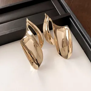 Detailweergave van gouden onregelmatige blad oorbellen met hoogglanslak