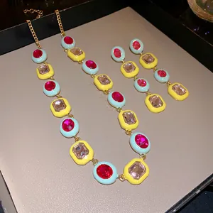 Detailansicht eines bunten geometrischen Halsketten- und Ohrring-Sets mit Edelsteinen.