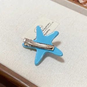 Light blue acrylic starfish hair clip with silver metal back for coastal vacation styling