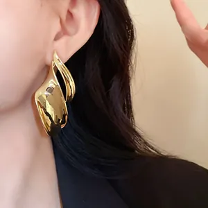 Zijaanzicht detail van een vrouwelijk model met gouden onregelmatige blad oorbellen